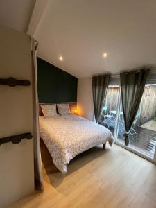 1 dormitorio con cama y ventana grande en Jolie maison Ares, en Arès