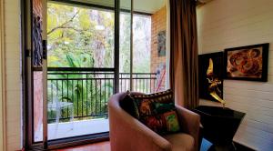 uma sala de estar com uma cadeira e uma grande janela em Quaint & Tranquil Subiaco 1 Bedroom Apartment em Perth
