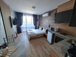 um quarto com uma cozinha com uma cama em MitProt Panorama Bay 2 Studio 206 em Sveti Vlas