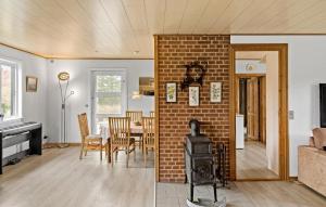 - un salon et une salle à manger avec une cheminée en briques dans l'établissement Beautiful Home In Stege With Wifi, à Stege