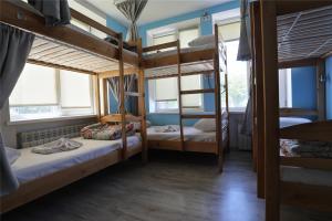 a room with three bunk beds and two windows at Light Life Hostel in Kyiv