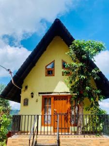 una casa gialla con tetto di paglia di Twilight Villas a Rattota