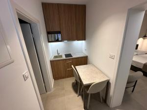 a small kitchen with a small table and a bed at Apartment & Room IRIS in Zadar