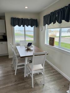 a dining room with a table and chairs and two windows at Quaint, family friendly Beach house for 4 in South Dartmouth