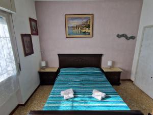 een slaapkamer met een bed met 2 kussens erop bij Casa rosario e annamaria in Torri del Benaco