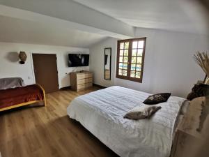 a bedroom with a large white bed and a window at La planque de l'éclusier in Castelnau-de-Lévis