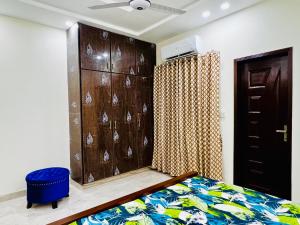 a bedroom with a bed and a wooden cabinet at Sj Luxury Suits in Lahore