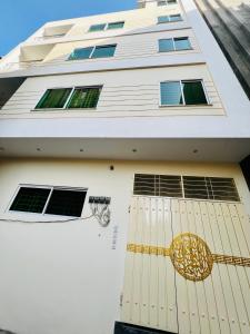 a white building with a gold door and windows at Sj Luxury Suits in Lahore