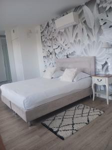 1 cama en un dormitorio con un mural en la pared en Quetzal, en Villars-les-Dombes