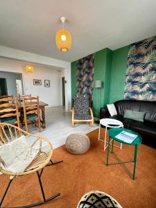 - un salon avec un canapé, des chaises et une table dans l'établissement La Mer à Pied appartement vue mer, à Dieppe