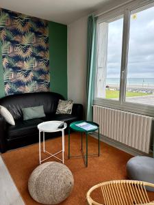 - un salon avec un canapé noir et une table dans l'établissement La Mer à Pied appartement vue mer, à Dieppe