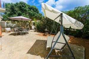 a white umbrella and a tripod in a yard at SanVitoTour- Residence Il Baglio in San Vito lo Capo
