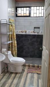 een badkamer met een toilet en een douche bij Tranquilo, WIFI y cerca de playas, ArLiz House in Guanacaste