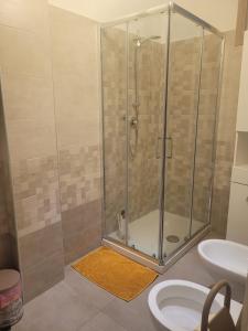 La salle de bains est pourvue d'une douche avec une porte en verre. dans l'établissement Tiny Green apartament in Rome - Magliana, à Rome