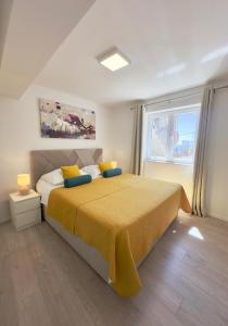 una camera da letto con un grande letto con una coperta gialla di Apartment Dvina a Dubrovnik