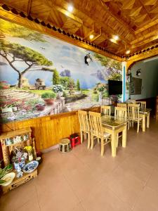 a dining room with a large painting on the wall at Viet Duc Guest House in Sapa