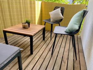 2 sedie e un tavolo su una terrazza con tavolo e 2 cuscini di Bamboo Village a Magdeburgo