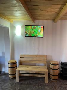 un banco de madera con TV en la pared en Twilight Villas, en Rattota