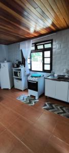 a kitchen with white appliances and a wooden ceiling at Residência Vô José - Casa 02 in Pomerode
