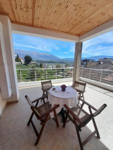 a patio with a table and chairs on a balcony at George's Apartment in Gjirokastër