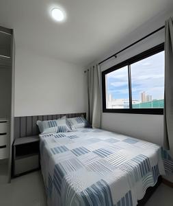 a bedroom with a bed and a large window at Apt equipado com estacionamento in Salvador