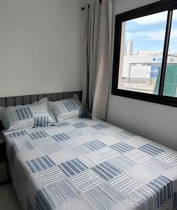 a bed in a room with a window at Apt equipado com estacionamento in Salvador