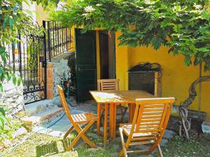a wooden table and chairs in front of a building at Casa vacanze Dolce Glicine in Bonassola