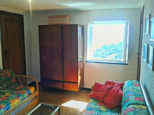 a bedroom with a bed and a cabinet and a window at Casa vacanze Dolce Glicine in Bonassola