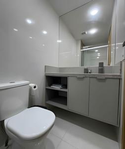 a white bathroom with a toilet and a sink at Apt equipado com estacionamento in Salvador