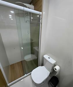 a bathroom with a toilet and a glass shower at Apt equipado com estacionamento in Salvador