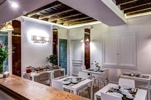 ローマにあるGood Life Montiの白いテーブルと白い椅子が備わるレストラン