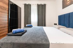 a bedroom with a large bed with blue pillows on it at Apartment Black Diamond in Ražanac