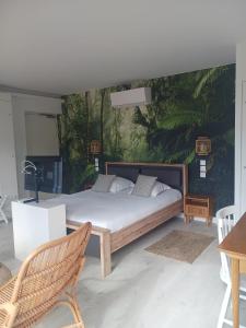 1 dormitorio con 1 cama y una pared con un mural en Aracari, en Villars-les-Dombes