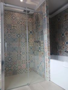 y baño con ducha y puerta de cristal. en Aracari, en Villars-les-Dombes