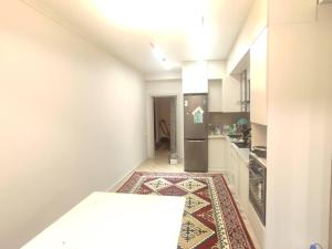 een hal met een keuken met een tapijt op de vloer bij Элитная квартира со всеми удобствами в центре города Каракол in Karakol