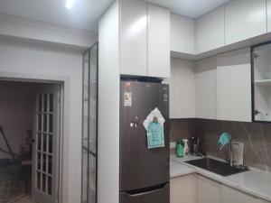 een keuken met een koelkast met papier erop bij Элитная квартира со всеми удобствами в центре города Каракол in Karakol