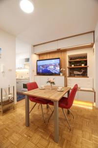 comedor con mesa de madera y sillas rojas en MHOUSE, en Piran