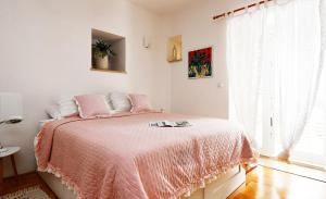 a bedroom with a pink bed with a pink blanket at Studio Sunny Garden in Dubrovnik +7 photos