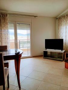 a living room with a flat screen tv and a table at Babis House in Limenaria