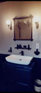 La salle de bains est pourvue d'un lavabo blanc et d'un miroir. dans l'établissement La terrasse de Roxane, à Bergerac
