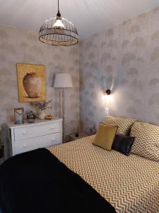 a bedroom with a bed and a dresser and a lamp at La terrasse de Roxane in Bergerac