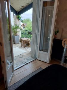 Une porte ouverte s'ouvre sur une terrasse avec une table. dans l'établissement La terrasse de Roxane, à Bergerac