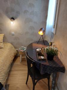 - une chambre avec une table, une lampe et un lit dans l'établissement La terrasse de Roxane, à Bergerac