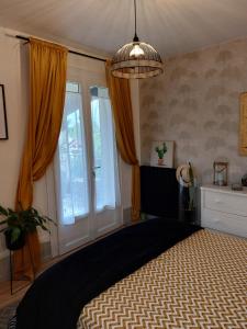 - une chambre avec un lit et une grande fenêtre dans l'établissement La terrasse de Roxane, à Bergerac