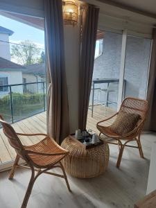 Habitación con 2 sillas, mesa y balcón. en Aracari, en Villars-les-Dombes