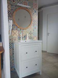 baño con lavabo y espejo en la pared en Aracari, en Villars-les-Dombes
