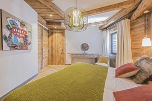 ヴァル・ディゼールにあるPenthouse Le Savoie - LES CHALETS COVARELのベッドルーム(緑のベッド1台、シャンデリア付)