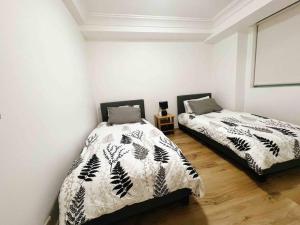 two beds in a room with white walls at Darling harbour & ICC & CBD & Chinatown & Spacious in Sydney