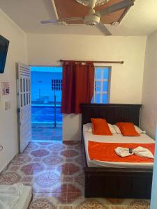 - une chambre avec un lit doté de draps orange et une fenêtre dans l'établissement Hotel san Jorge, à Melgar