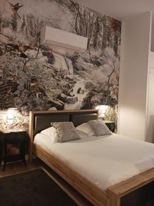 a bedroom with a bed and a wall mural at Calao in Villars-les-Dombes